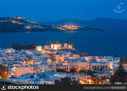 Traditional windmills at sunset, Santorini, Greece. Aerial view with traditional windmills on the island Mykonos, The island of the winds, during evening blue hour, Greece