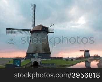 Traditional windmills in a dutch landscape in the Netherlands at sunset
