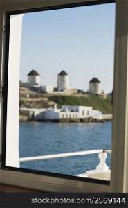 Traditional windmills viewed through a window, Mykonos, Cyclades Islands, Greece