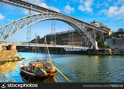 Traditional wine boats and Dom Luis I bridge in Porto, Portugal
