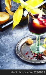 Traditional winter alcohol drink. Glass with red mulled wine with apple and spices