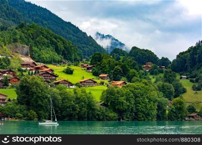 Traditional wood and modern houses along the Lake Brienz in swiss village Iseltwald, Switzerland. Swiss village Iseltwald, Switzerland