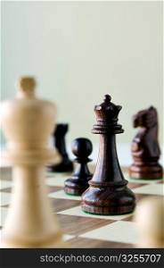 Traditional wooded chess game pieces on playing board.