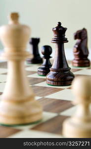 Traditional wooded chess game pieces on playing board.