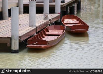 Traditional wooden boats of Thailand floating on the water in the port of trading in water market.