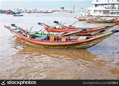 Traditional wooden fisher boats in the harbor from Yangon in Myanmar