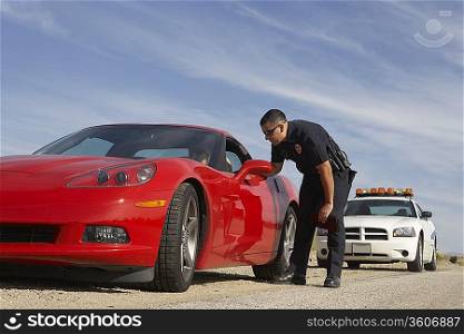 Traffic cop talking with driver of red sports car