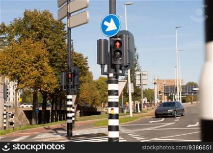 Traffic light-regulated intersection with road signs. Red traffic light. Road markings. Traffic light-regulated intersection with road signs. Red traffic light