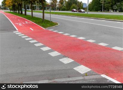traffic, marking and city concept - red bike lane or road crossing with signs only for bicycles and two way arrows on street. bike lane or red road with signs only for bicycles