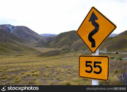 Traffic sign in New Zealand with reference to road with curves