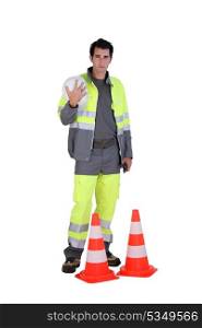 Traffic worker stood by cone