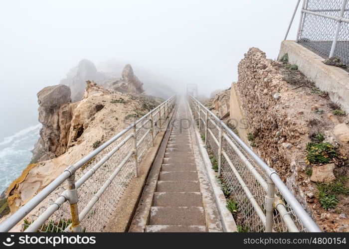 Trail through white fog to Point Reyes Lighthouse at Pacific coast, California, USA