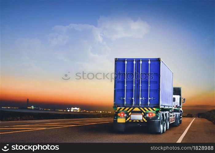 Trailer truck with container running on highway to the industrial estate at evening time