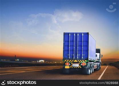 Trailer truck with container running on highway to the industrial estate at evening time