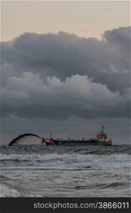 trailing suction hopper dredger with thunder coulds at sea