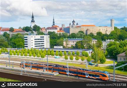 Train arrives to Tallin. Old Town of Tallin in the background. Estonia