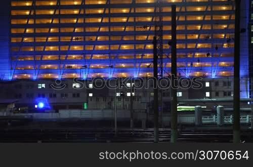 train passing by the lighted building in the city at night