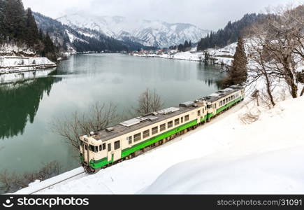 Train with Winter landscape snow and village on lake