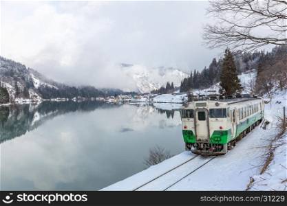Train with Winter landscape snow and village on lake
