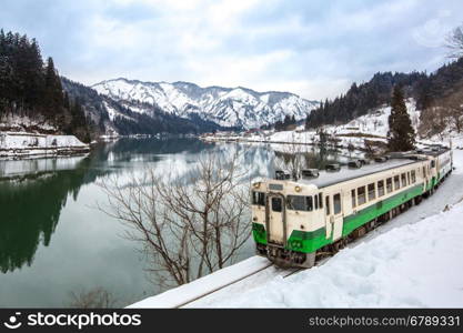 Train with Winter landscape snow and village on lake