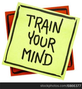 train your mind advice or reminder - handwriting in black ink on an isolated sticky note