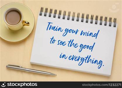 Train your mind to see the good in everything - inspirational handwriting in a sketchbook with a cup of coffee, positivity and personal development concept