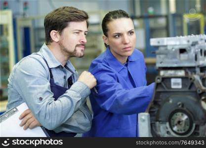 trainee female mechanic working under supervision