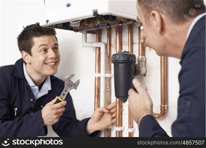 Trainee Plumber Working On Central Heating Boiler