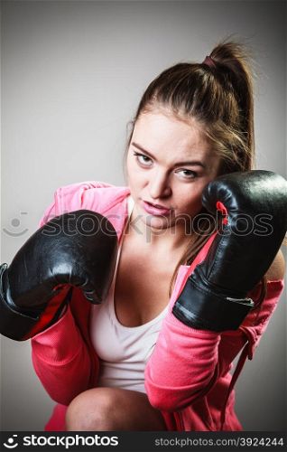 Training, boxing and exercises. Women lifestyle concept. Fit girl with gloves on grey background in studio.