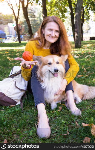 training - girl and dog corgi walking in the park