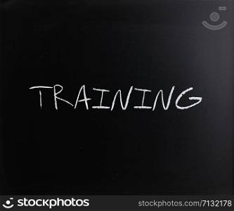 ""Training" handwritten with white chalk on a blackboard."