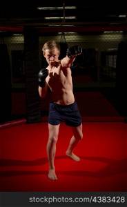 Training of young kickboxer at gym