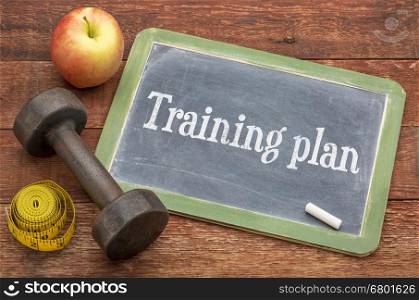 Training plan - slate blackboard sign against weathered red painted barn wood with a dumbbell, apple and tape measure