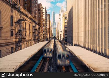 Trains arriving railway station between buildings in downtown Chicago, Illinois. Urban public transportation, USA landmark, or American Midwest city life concept