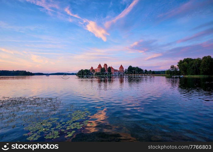 Trakai Island Castle in lake Galve, Lithuania on sunset with dramatic sky reflecting in water. Trakai Castle is one of major tourist attractions of Lituania. Trakai Island Castle in lake Galve, Lithuania