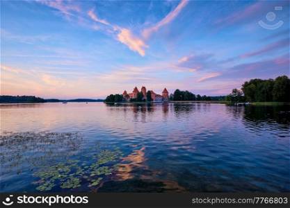 Trakai Island Castle in lake Galve, Lithuania on sunset with dramatic sky reflecting in water. Trakai Castle is one of major tourist attractions of Lituania. Trakai Island Castle in lake Galve, Lithuania