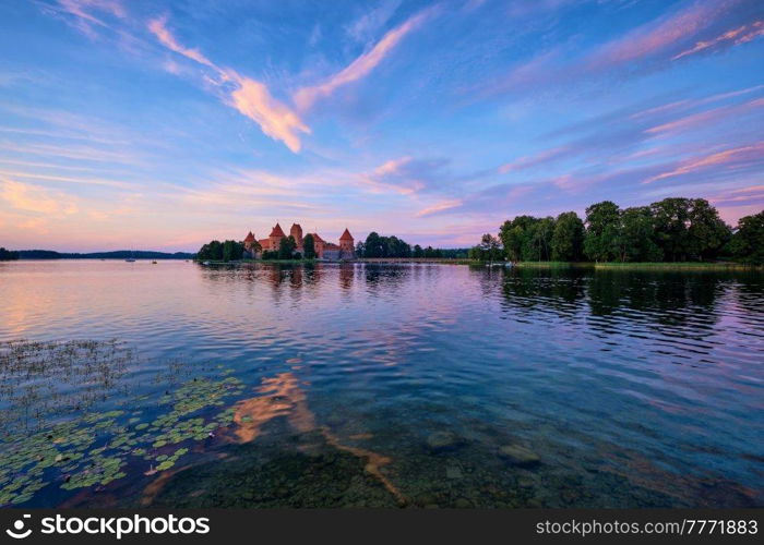 Trakai Island Castle in lake Galve, Lithuania on sunset with dramatic sky reflecting in water. Trakai Castle is one of major tourist attractions of Lituania. Trakai Island Castle in lake Galve, Lithuania