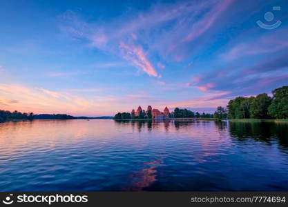 Trakai Island Castle in lake Galve, Lithuania on sunset with dramatic sky reflecting in water. Trakai Castle is one of major tourist attractions of Lituania, now museum and cultural center. Europe. Trakai Island Castle in lake Galve, Lithuania