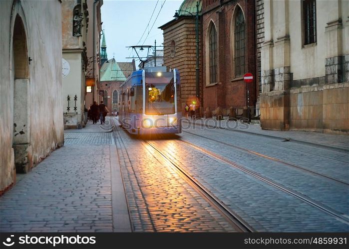 Tram on european city street at night