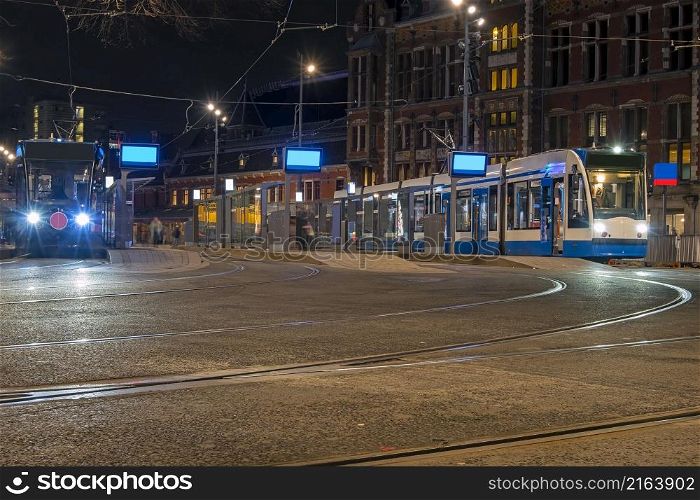 Trams waiting at the Central Station in Amsterdam in the Netherlands at night