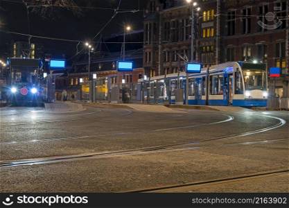 Trams waiting at the Central Station in Amsterdam in the Netherlands at night