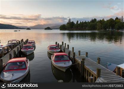 Tranquil dusk scene of Boats moored in piers in Lake Windermere in Cumbria