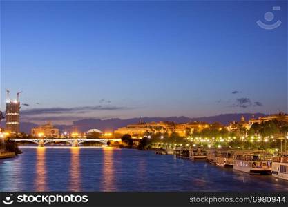 Tranquil evening in the City of Seville by the Guadalquivir river in Spain.