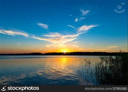 tranquil lake and the setting sun over the horizon