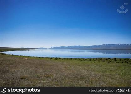 Tranquil lake Sonkul with blue sky in Kyrgyzstan.