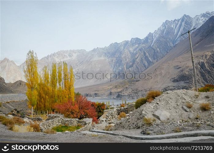 Tranquil scenery of a small village in Passu against snow capped mountain in Karakoram range. Autumn season in Gilgit Baltistan, Pakistan.