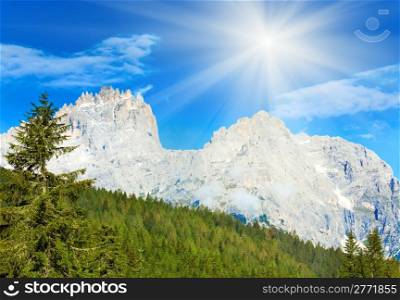 Tranquil summer Italian dolomites mountain and sunshine in blue sky