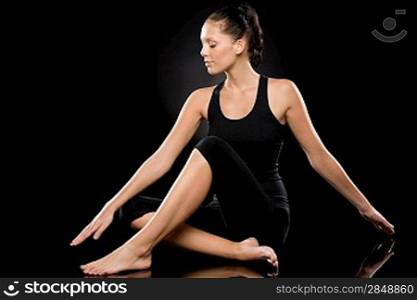 Tranquil young and barefoot woman performing yoga with stretched arms