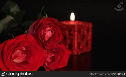 Transfer of focus from red rose on candle.