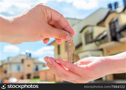 transfer to the buyer of the house key close-up of hands against the sky